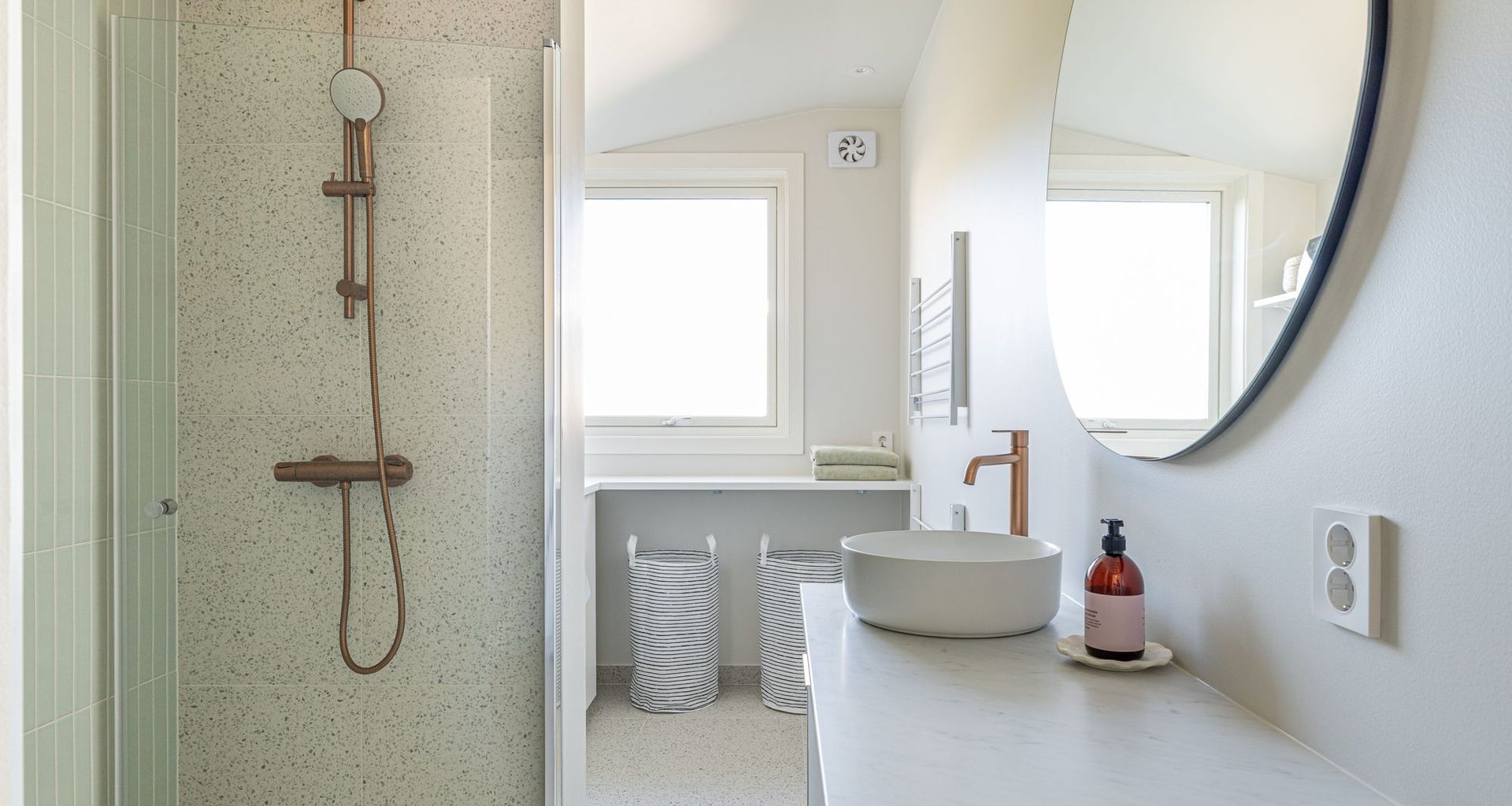 Oppussing av bad i en lys, minimalistisk stil. Rommet kombinerer nå bad og vaskerom, for en praktisk løsning for kundene. Det er også et vindu på badet som gir godt med naturlig dagslys. Badet er totalrenovert av Lomundal.