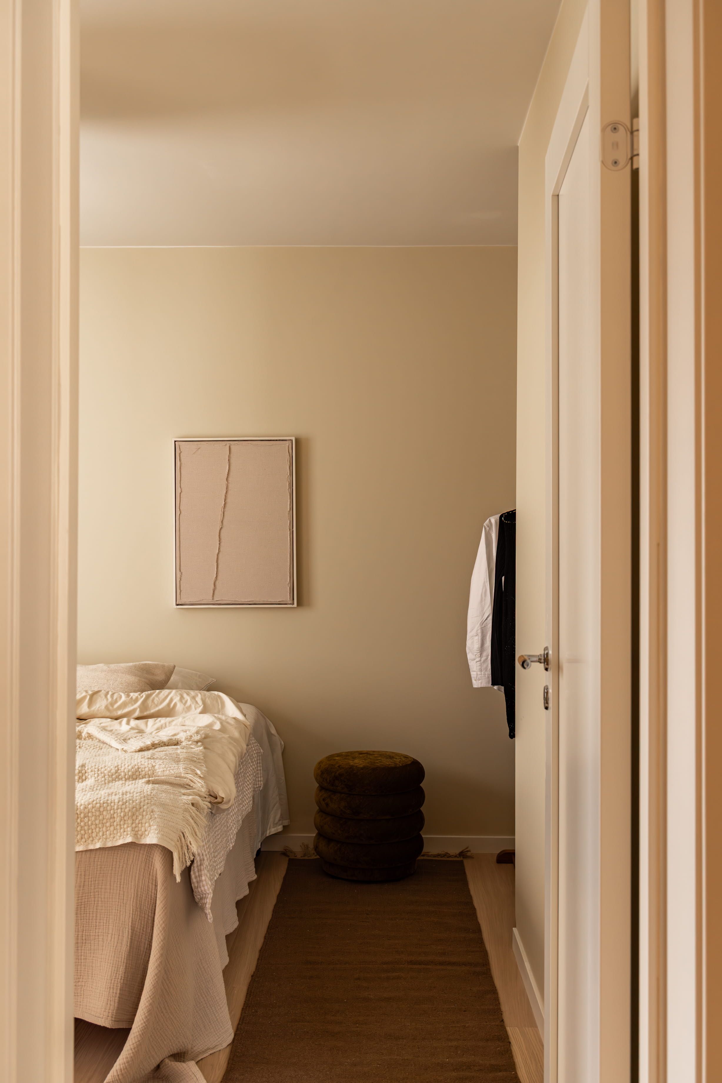 Soverom med beige vegger med et sømløst og minimalistisk uttrykk. Soverommet er totalrenovert av Lomundal.