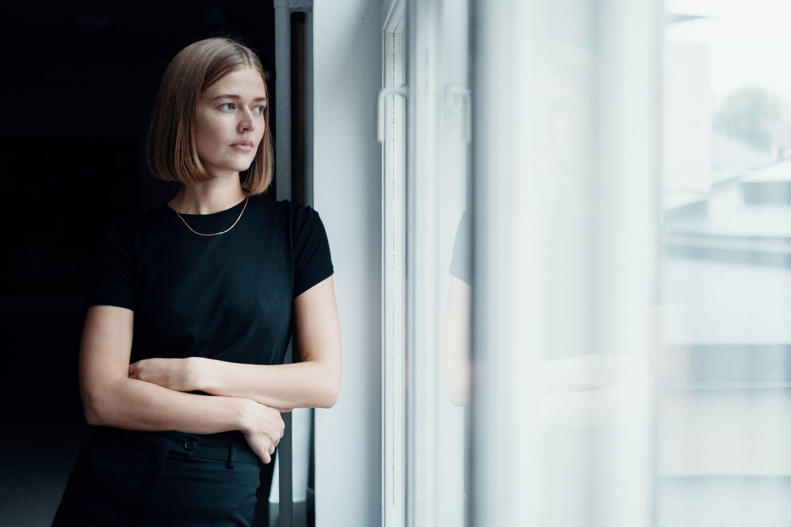 Ingrid ser ut av vindu. Ingrid jobber som markedskoordinator hos Lomundal.