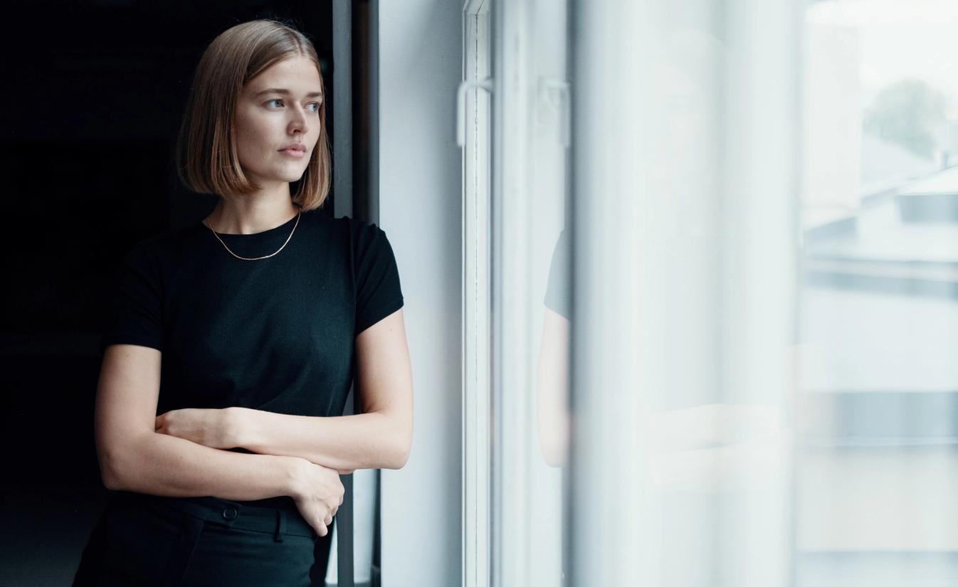 Ingrid ser ut av vindu. Ingrid jobber som markedskoordinator hos Lomundal.