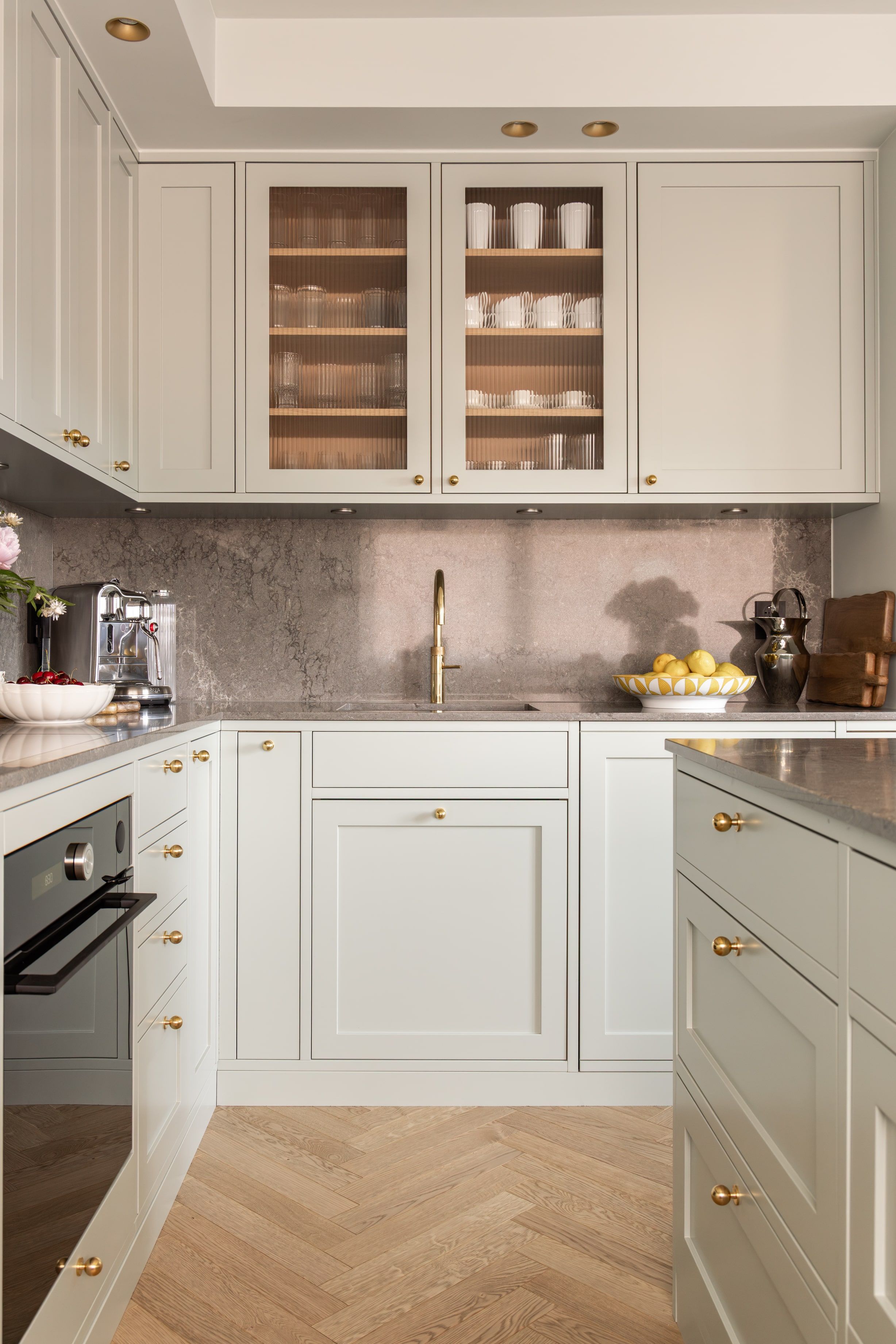 Klassisk kjøkken i en mintgrønn tone. Kjøkkenet har et klassisk uttrykk med profilerte kjøkkenfronter og rillet glass. Benkeplaten og backsplashet er i kvartskomposittstein som skaper en fin kontrast. Utført av Lomundal.
