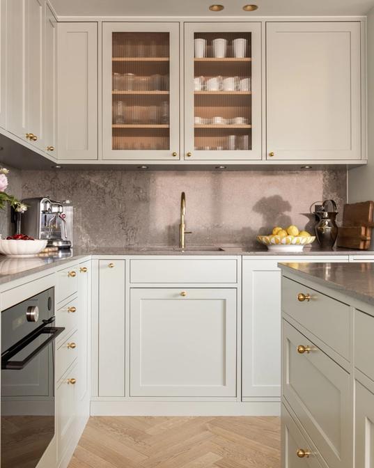 Klassisk kjøkken i en mintgrønn tone. Kjøkkenet har et klassisk uttrykk med profilerte kjøkkenfronter og rillet glass. Benkeplaten og backsplashet er i kvartskomposittstein som skaper en fin kontrast. Utført av Lomundal.