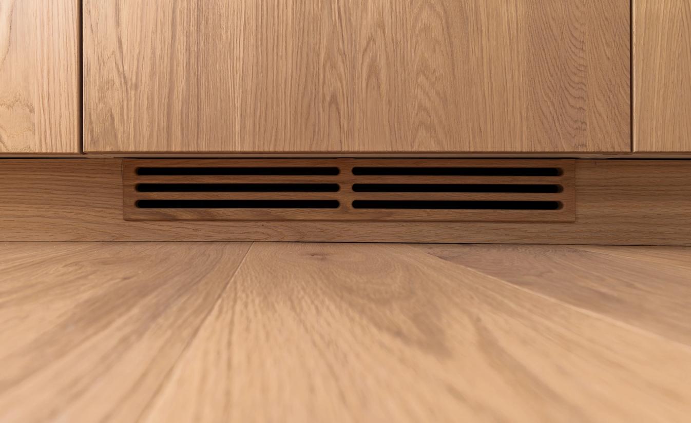 Detaljbilde av kjøkkeninnredning og gulv i lys eik. Totalrenoveringen er utført av Lomundal.