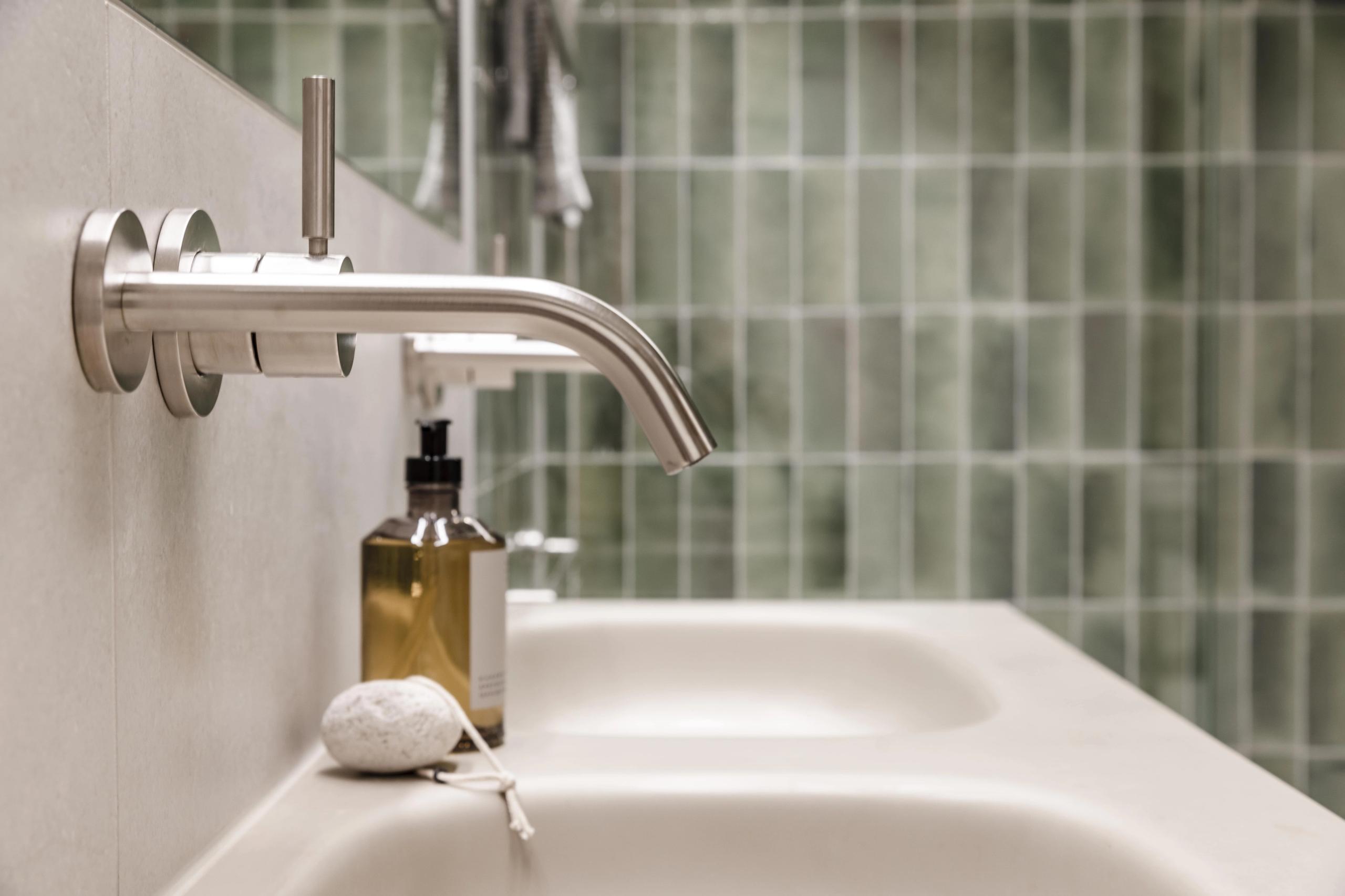 Detaljbilde av dobbel nedfelt vask fra Antionio Lupi med innebygde armaturer fra Dornbracht over i Platinum Matt. På vasken står en såpe fra Frama.