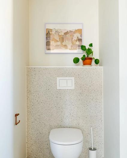Bad i nordisk, minimalistisk stil med malte flater i Sommersne fra Jotun, kombinert med en nøytral flis med terrazzomønster. På badet er det også en flissokkel i terrazzoflis som skaper et helhetlig uttrykk mellom vegg og gulv. Badet er totalrenovert av Lomundal.