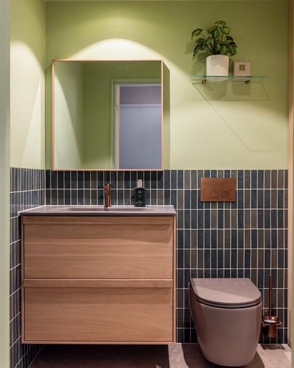 Lyst bad i friske farger. Badet kombinerer beige nyanser med lyst treverk, og vegger i grønntoner. Et moderne, nyoppusset bad med personlig uttrykk. Utført av Lomundal.
