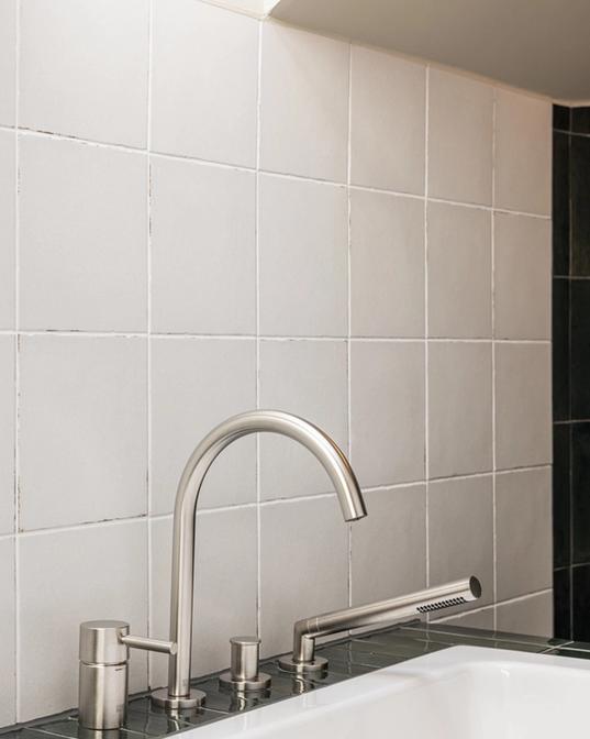 Detaljbilde av innebygde armaturer fra Dornbracht installert på badekar. Hvite kvadratiske fliser på vegg. Utført av Lomundal.
