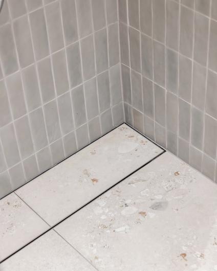 Lyst bad i Skandinavisk stil med terrazzoflis og matte mosaikkfliser. Utført av Lomundal.