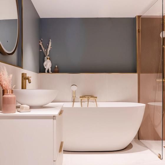 Baderom med rosa fliser i blå og rosa toner med frittstående badekar og detaljer i messing. Badet er totalrenovert av Lomundal.