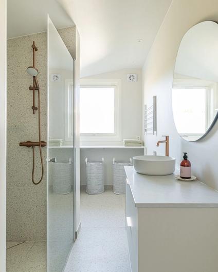 Oppussing av bad i en lys, minimalistisk stil. Rommet kombinerer nå bad og vaskerom, for en praktisk løsning for kundene. Det er også et vindu på badet som gir godt med naturlig dagslys. Badet er totalrenovert av Lomundal.
