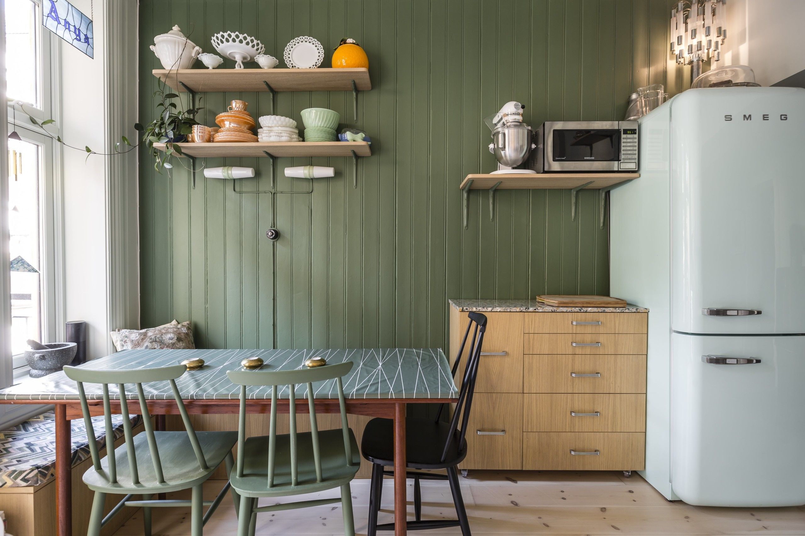 Retro kjøkken med grønne vegger, møblement i eik og kjøleskap fra Smeg, utført av Lomundal.