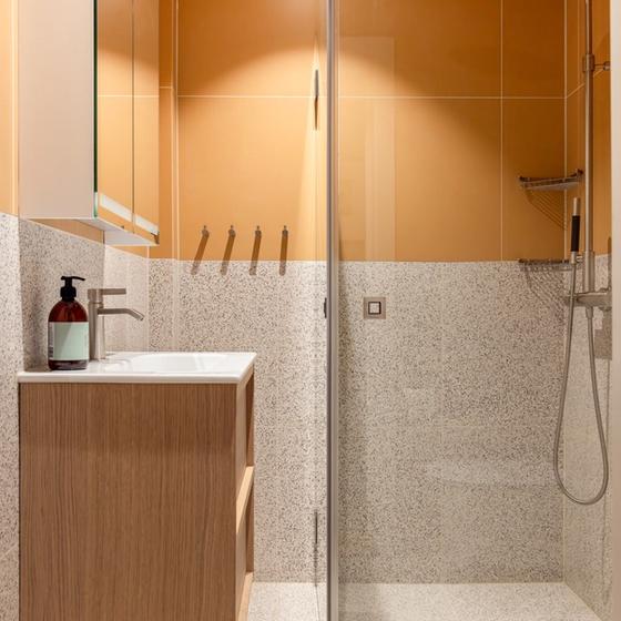 Et moderne bad med et retro og lekent uttrykk. Gulfargen og terrazzoflisene gir badet et unikt preg. Badet er totalrenovert av Lomundal.