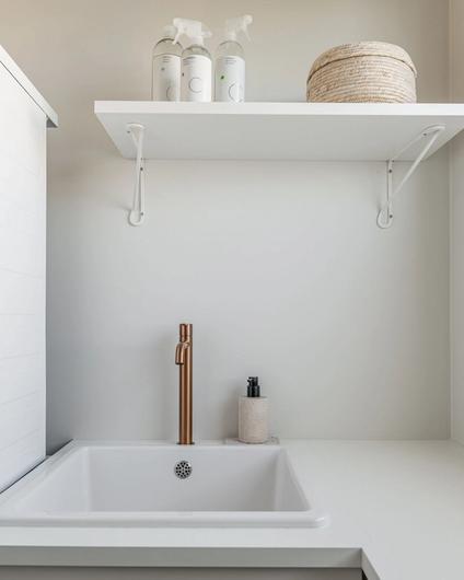 Lyst og tidløst vaskerom, med benkeplate, vask og plass til vaskemaskin og tørketrommel. Veggene er malt i Sommersne fra Jotun. Badet er totalrenovert av Lomundal.