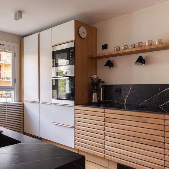 Lyst, nordisk kjøkken i eik. Eikelamellene og den keramiske benkeplaten skaper fine detaljer i rommet. Kjøkkenet er totalrenovert av Lomundal. Vi pusser opp bad og bolig i Stor-Oslo.