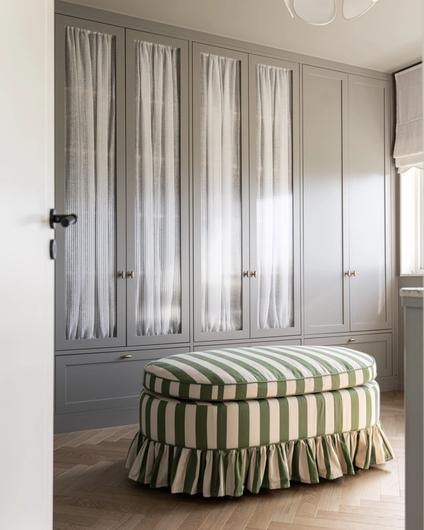 Walk-in garderobe med skap i gråtoner, med rillet glass og fiskebensparkett i lys eik. Utført av Lomundal.