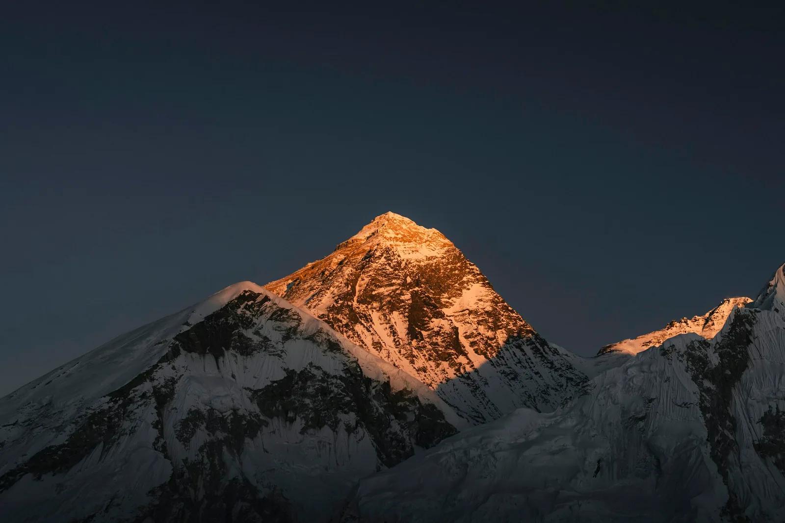 Die Gipfelpyramide des Mount Everest im goldenen Licht, vom Kala Patthar aus gesehen, während die Grate darunter schon im Schatten liegen