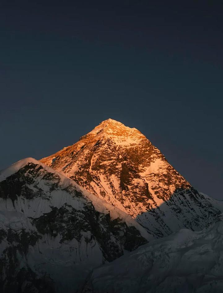 Die Gipfelpyramide des Mount Everest im goldenen Licht, vom Kala Patthar aus gesehen, während die Grate darunter schon im Schatten liegen