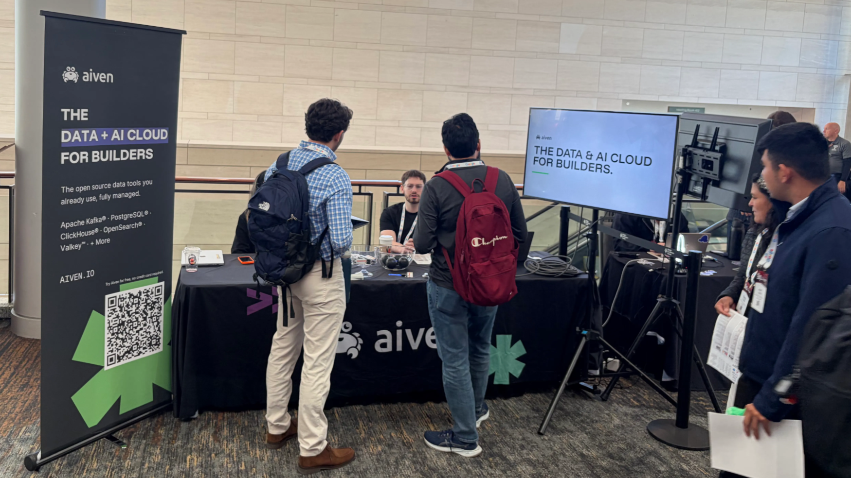 Conference attendees talking to Aiveners at our booth
