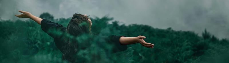 En jublende kvinne i en grønn skog