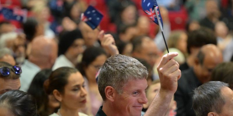 New Australian citizens waving Australian flags at Hills Shire Council citizenship ceremony