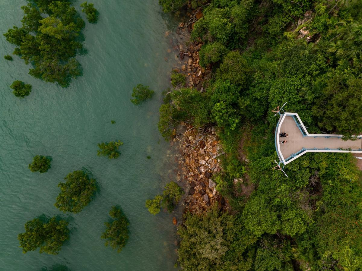 Aerial view of a coastal viewing deck in Darwin, Northern Territory, with mangroves, turquoise water and rocky shoreline.