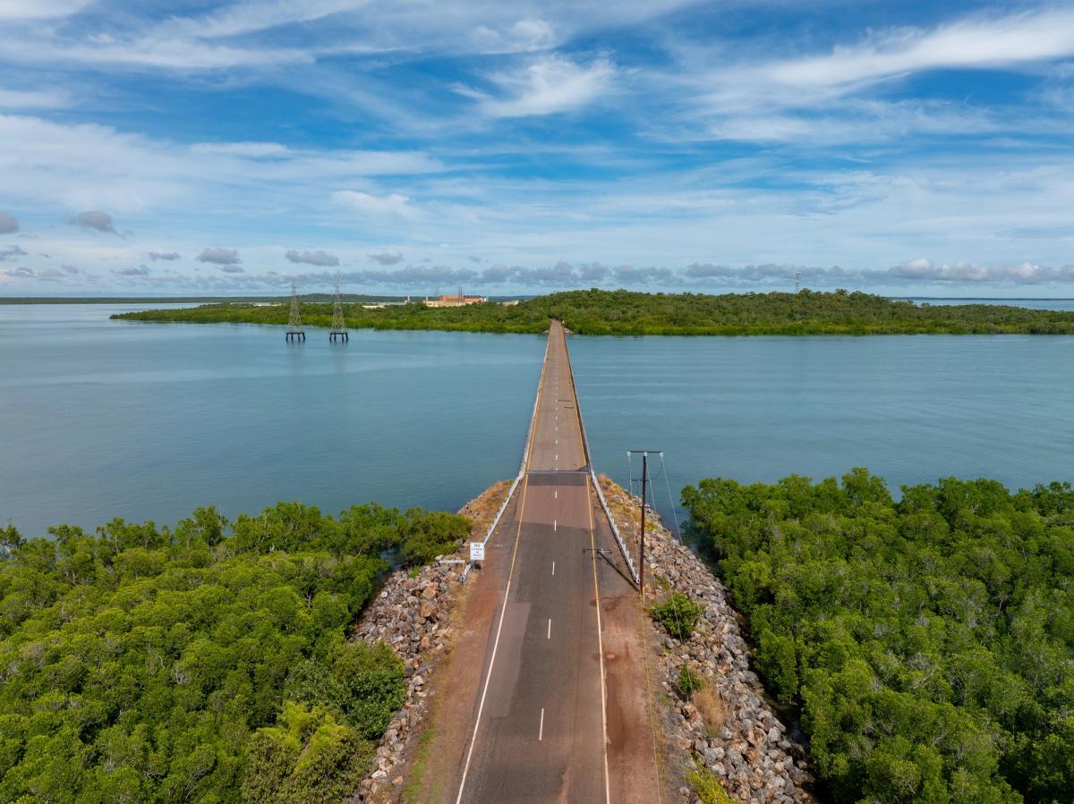 Aerial view of the causeway leading to Channel Island, Northern Territory, with mangroves either side and the gas-fired power station in the distance.