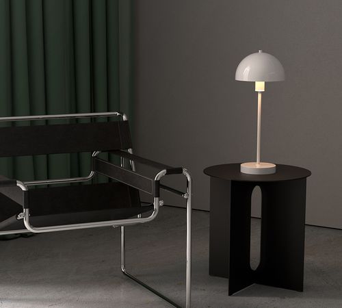 Hand som håller Atom bordslampa