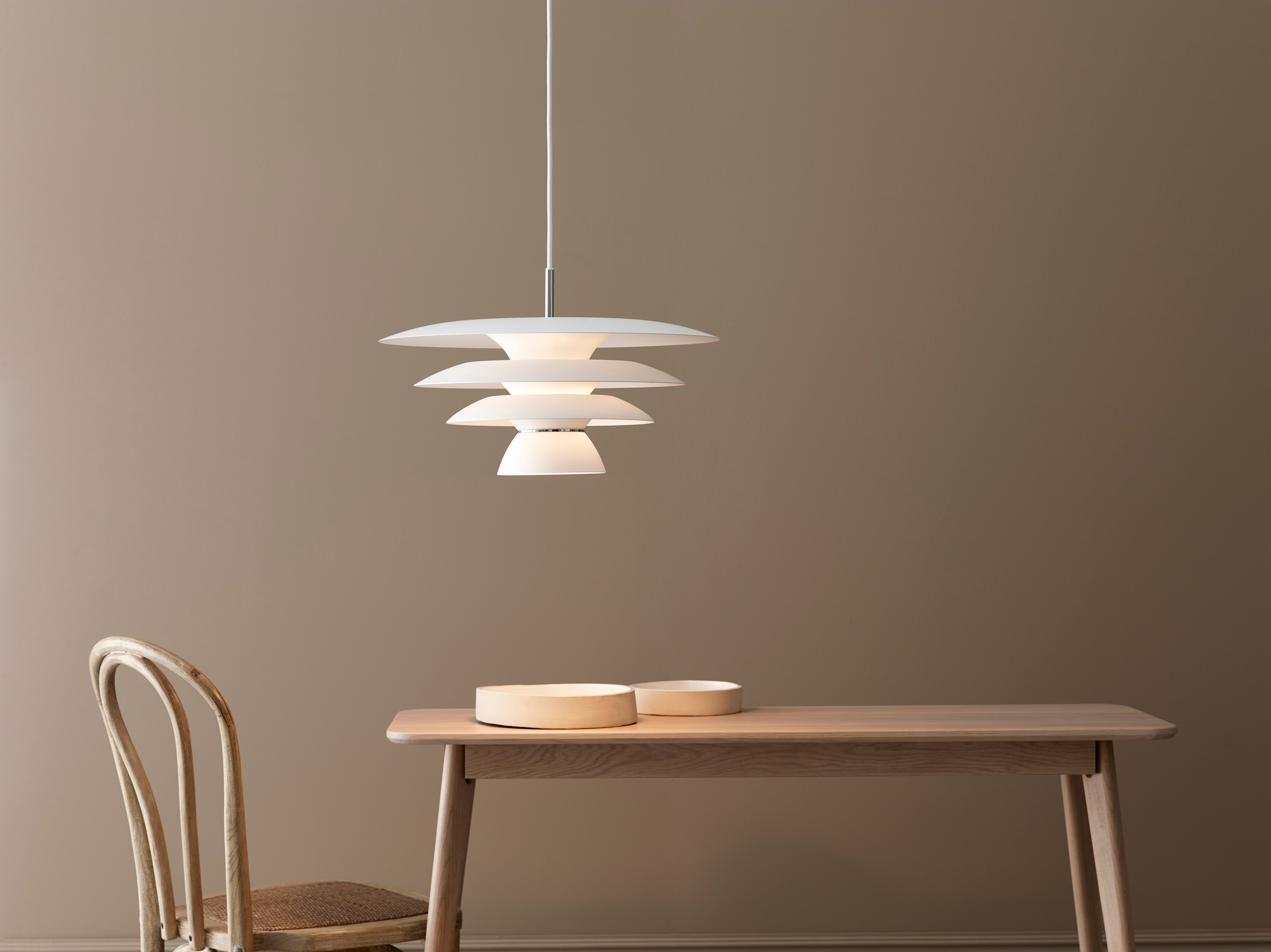 White pendant with three shades over an kitchen table in oak