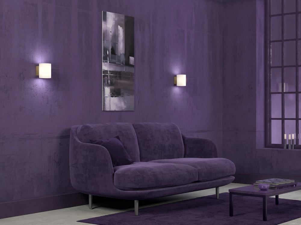 Two wall lamps on the wall behind a sofa