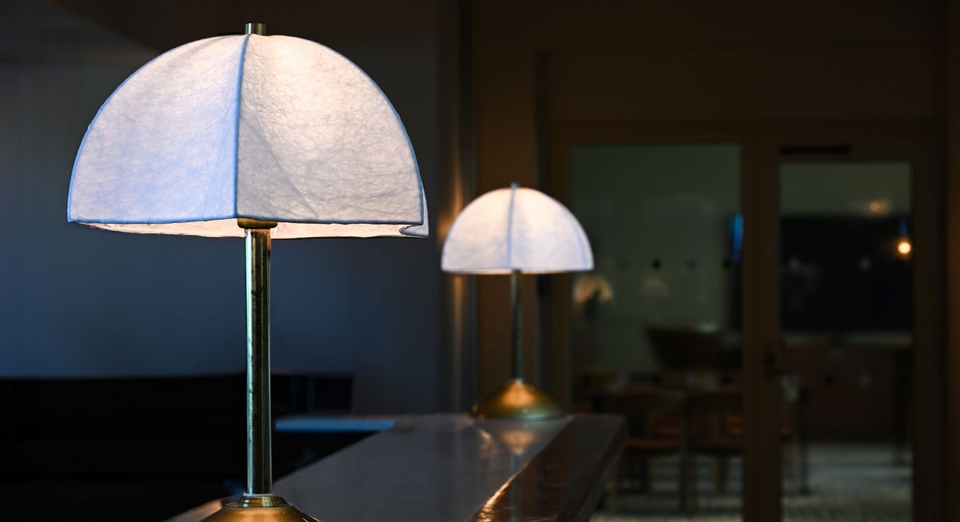 Specialdesignad bordslampa med mässingsfot och textilskärm, skapad för Hjortvikens bar.