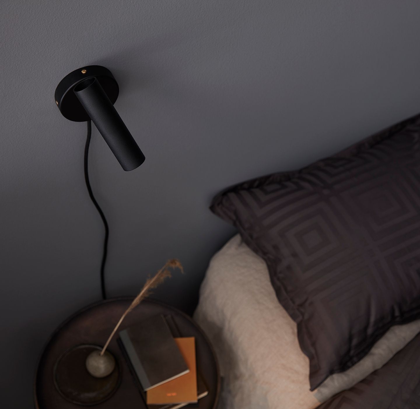 Slender wall lamp black beside the bed 