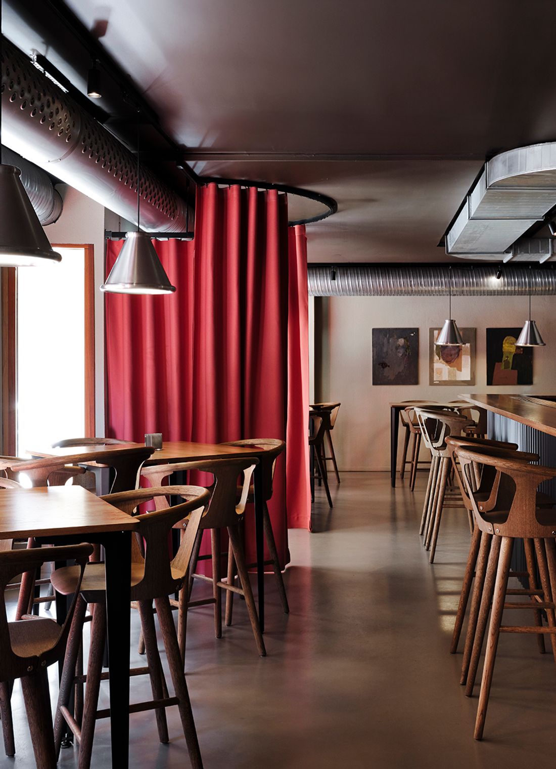 Långbord med trästolar upplysta av Belle-pendlar från Belid Lighting Group på Blokk i Göteborg. 