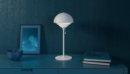 White table lamp on a table with books
