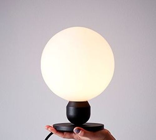 Hand holding Atom table lamp