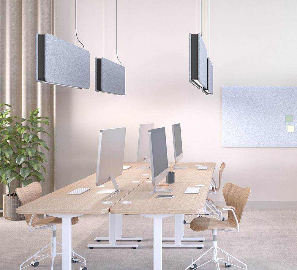 Grey sound absorbing pendant lamps over workstations in office space
