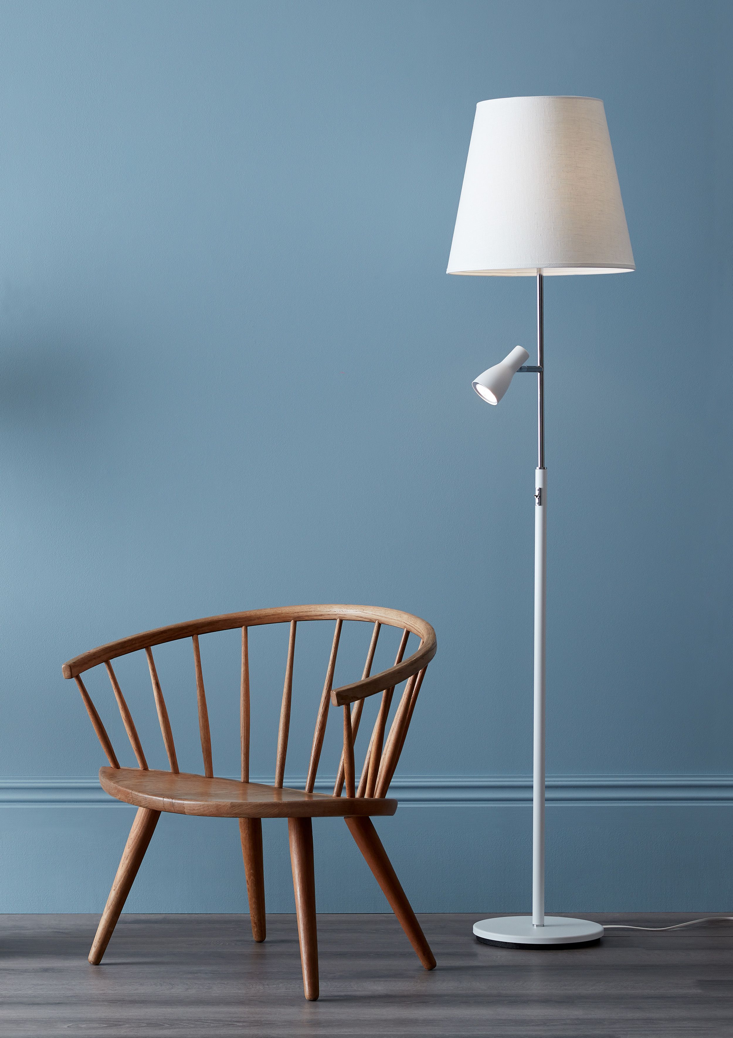 White floor lamp beside a chair