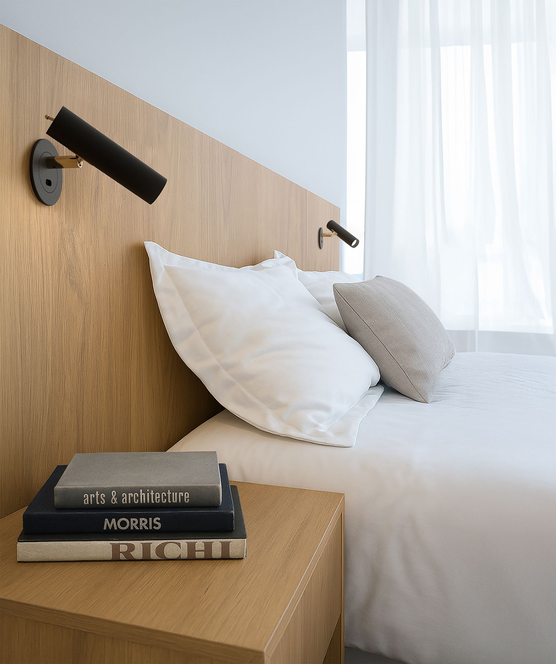 Slender X vägglampa bredvid sängen 