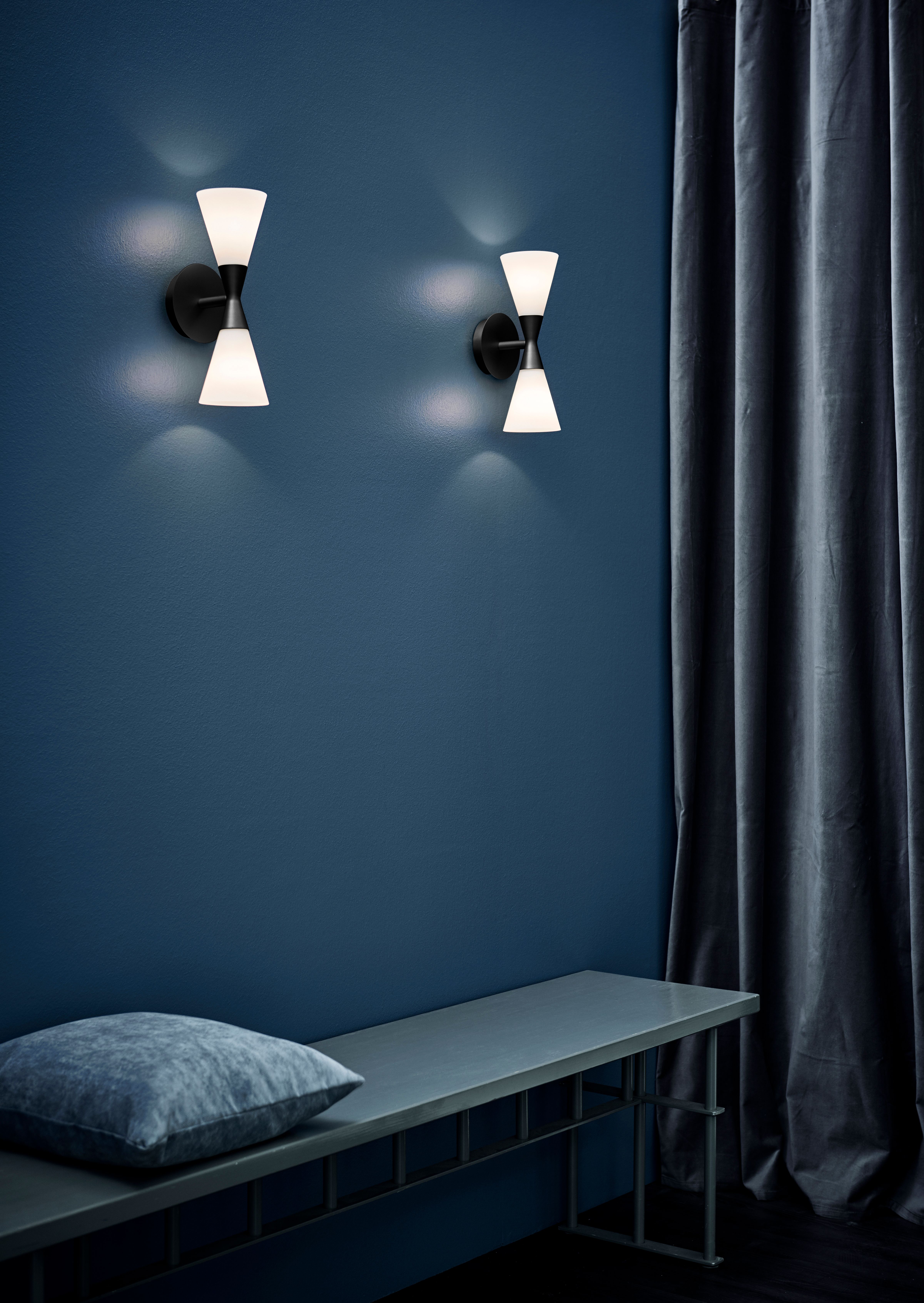 Two wall lamps in a blue room