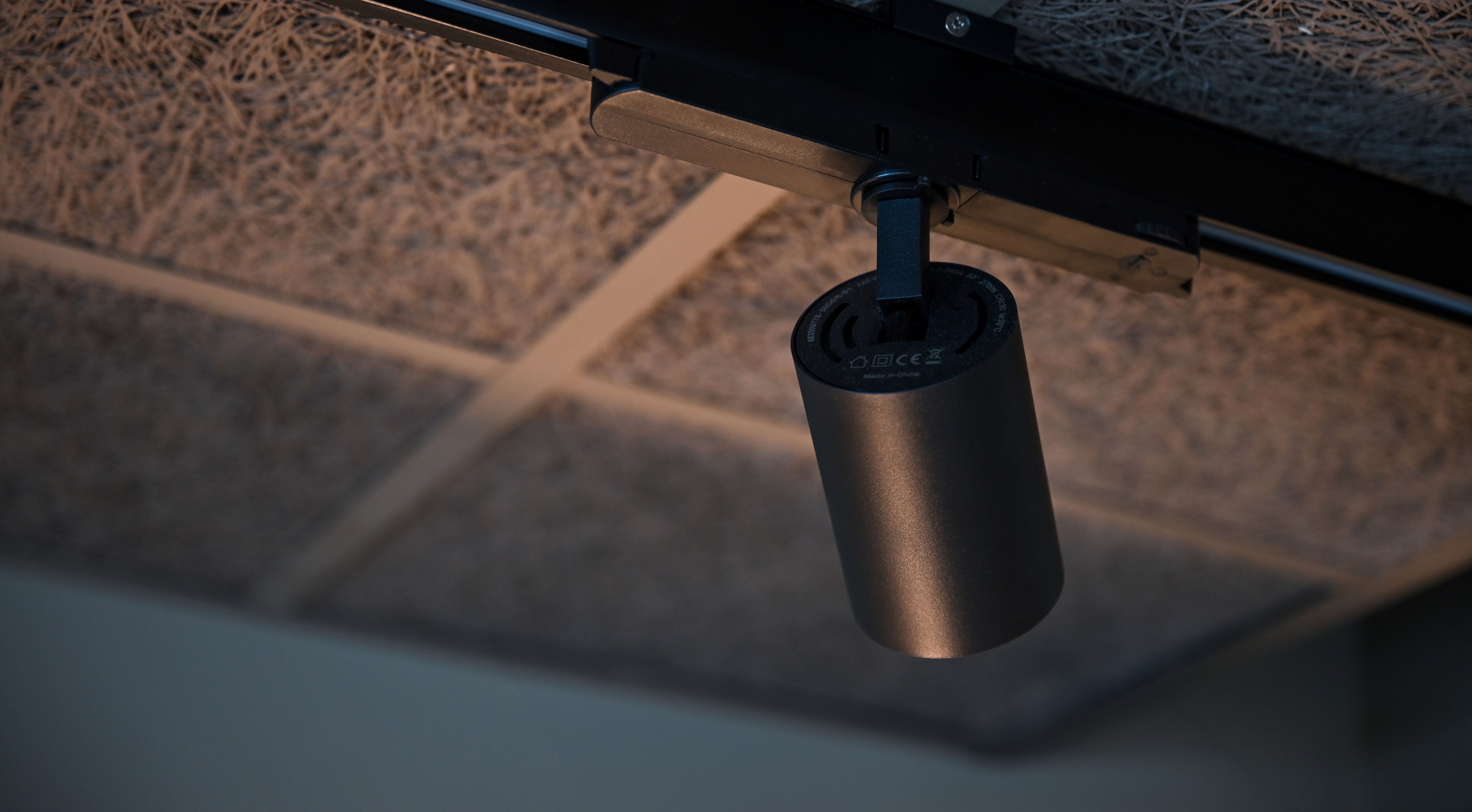 Black track spotlights from Belid Lighting in a modern interior with acoustic ceiling