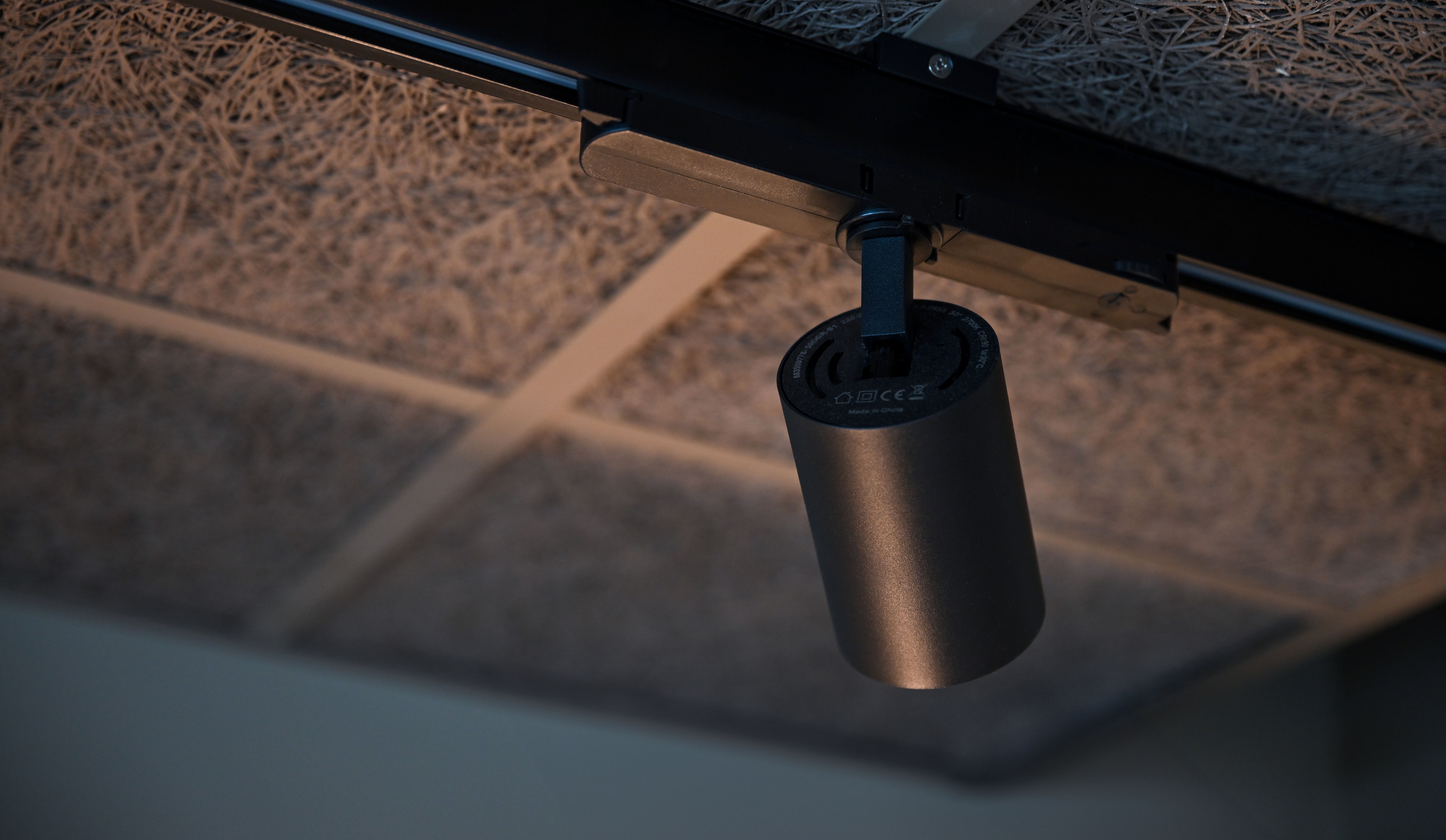 Svarta takspotlights på skensystem från Belid Lighting i modern interiör med akustiktak