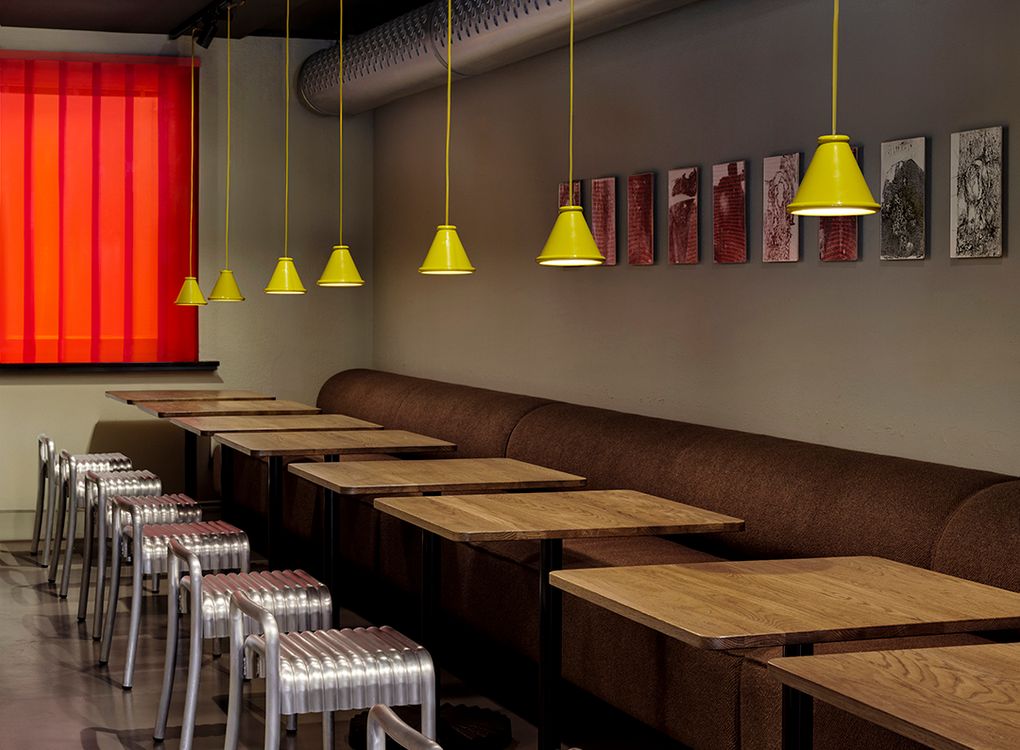 Gula Belle-pendlar från Belid Lighting Group som belyser träbord och metallstolar på restaurang Blokk i Göteborg. 