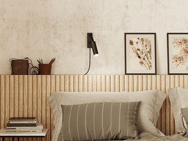 Black wall lamp beside bed