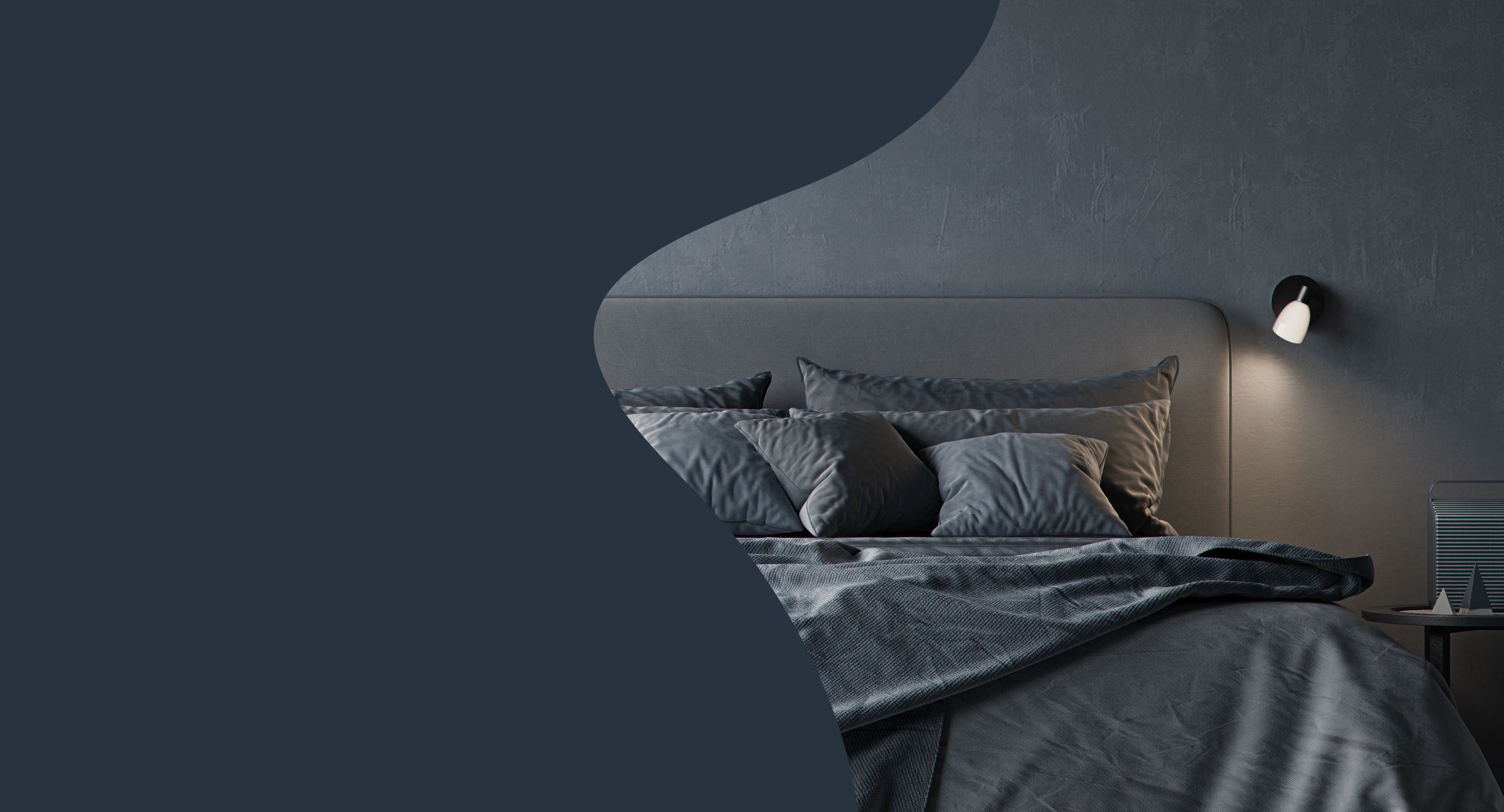 Wall lamp over a bed with gray linnen