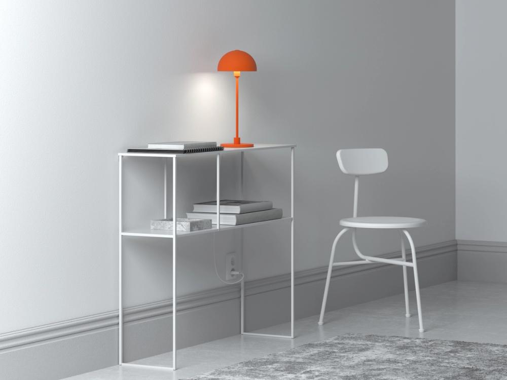 One orange table lamp on a white desk