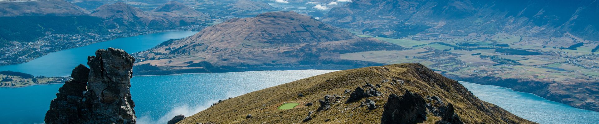 Golfers and helicopters in the alpine landscape above Queenstown