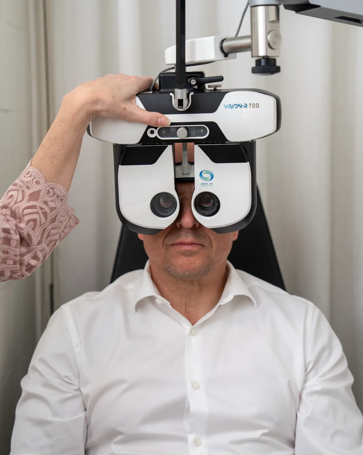 Mand kigger ind i Essilors digitale synsprøveudstyr Vision-R 700 under en synstest hos Optikhuset