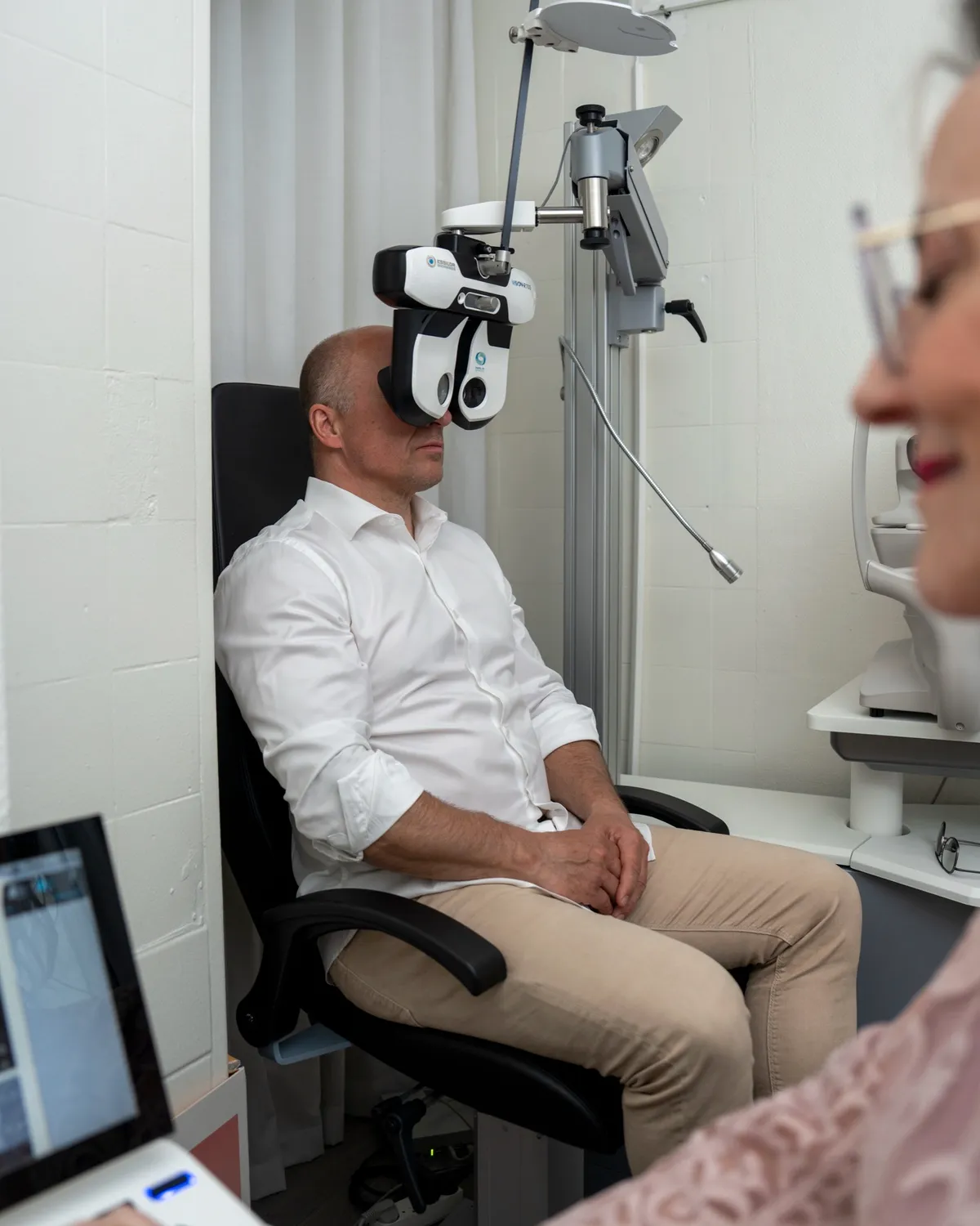 Synstest hos Optikhuset: en kunde sidder ved det digitale synsprøveudstyr med optikeren ved siden af
