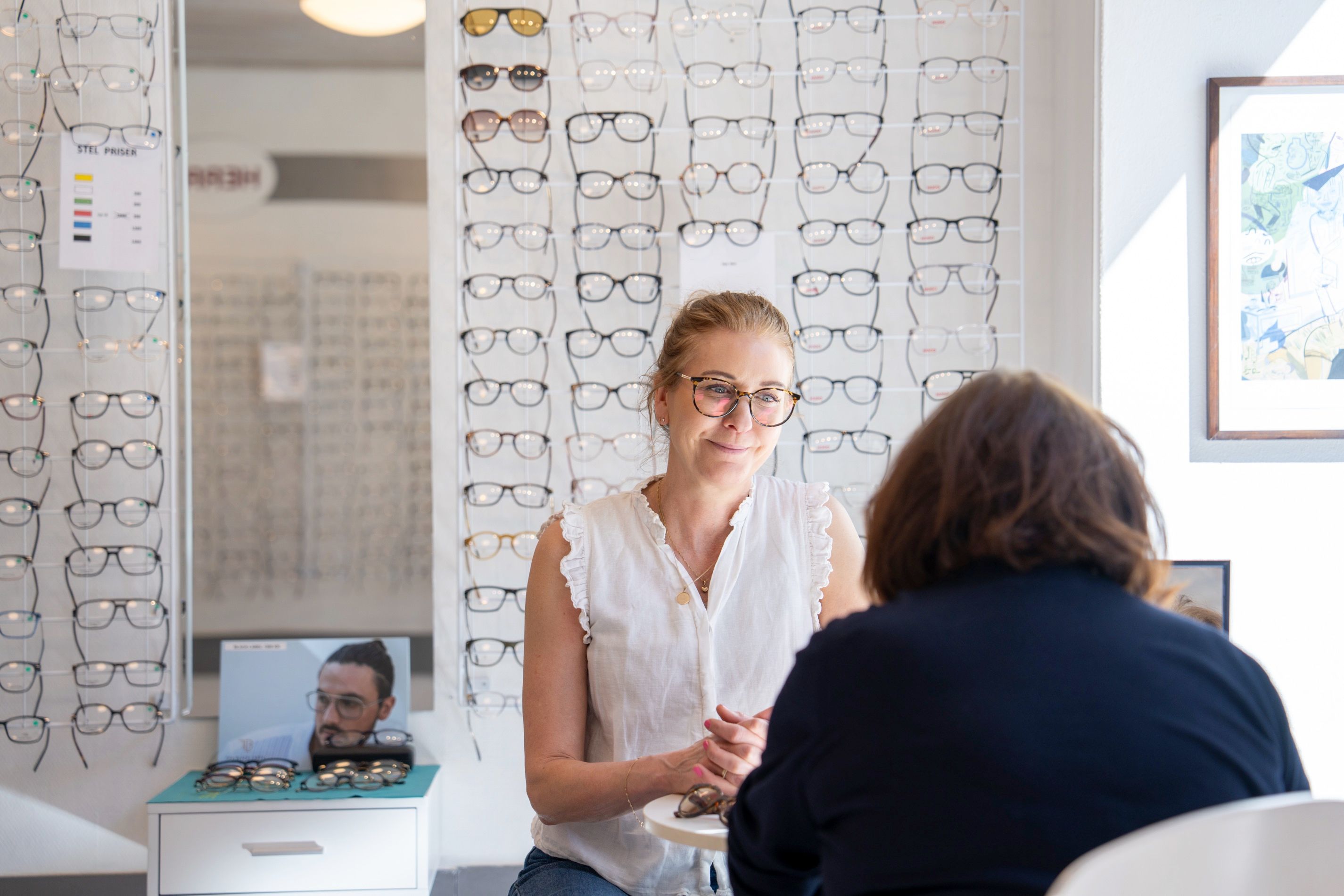 Erfaren optiker giver personlig rådgivning om briller til kunde på Frederiksberg