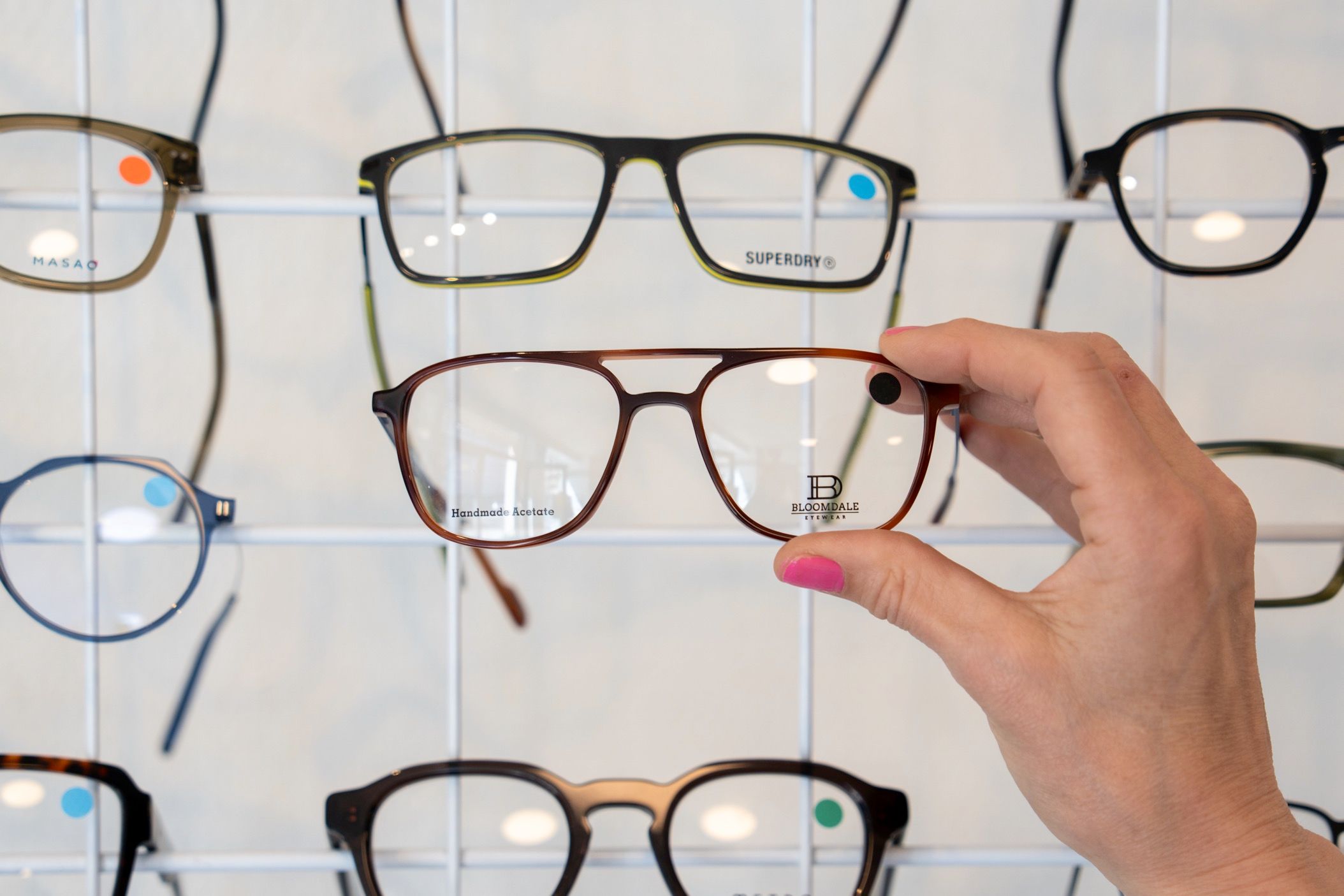 Forskelligartede brillestel fra kendte mærker som Pierre Cardin og HUGO udstillet på optiker