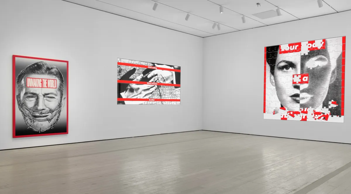 Large gallery space showcasing black, white, and red photographs of human figures. The photographs are overlaid with text, arranged meticulously on the wall.